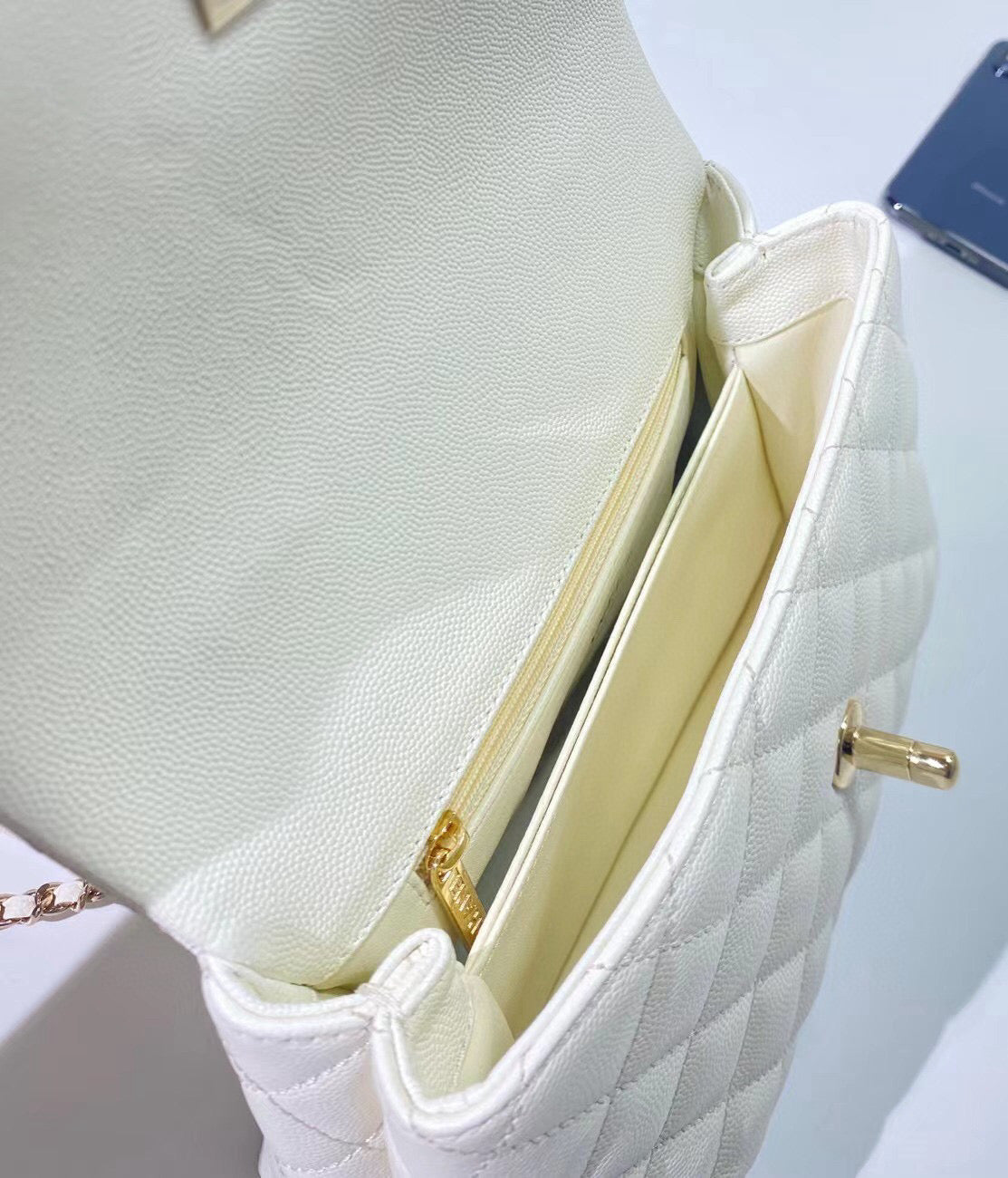 Sac à rabat avec poignée en coco 23 cm, blanc matelassé, caviar, quincaillerie or clair