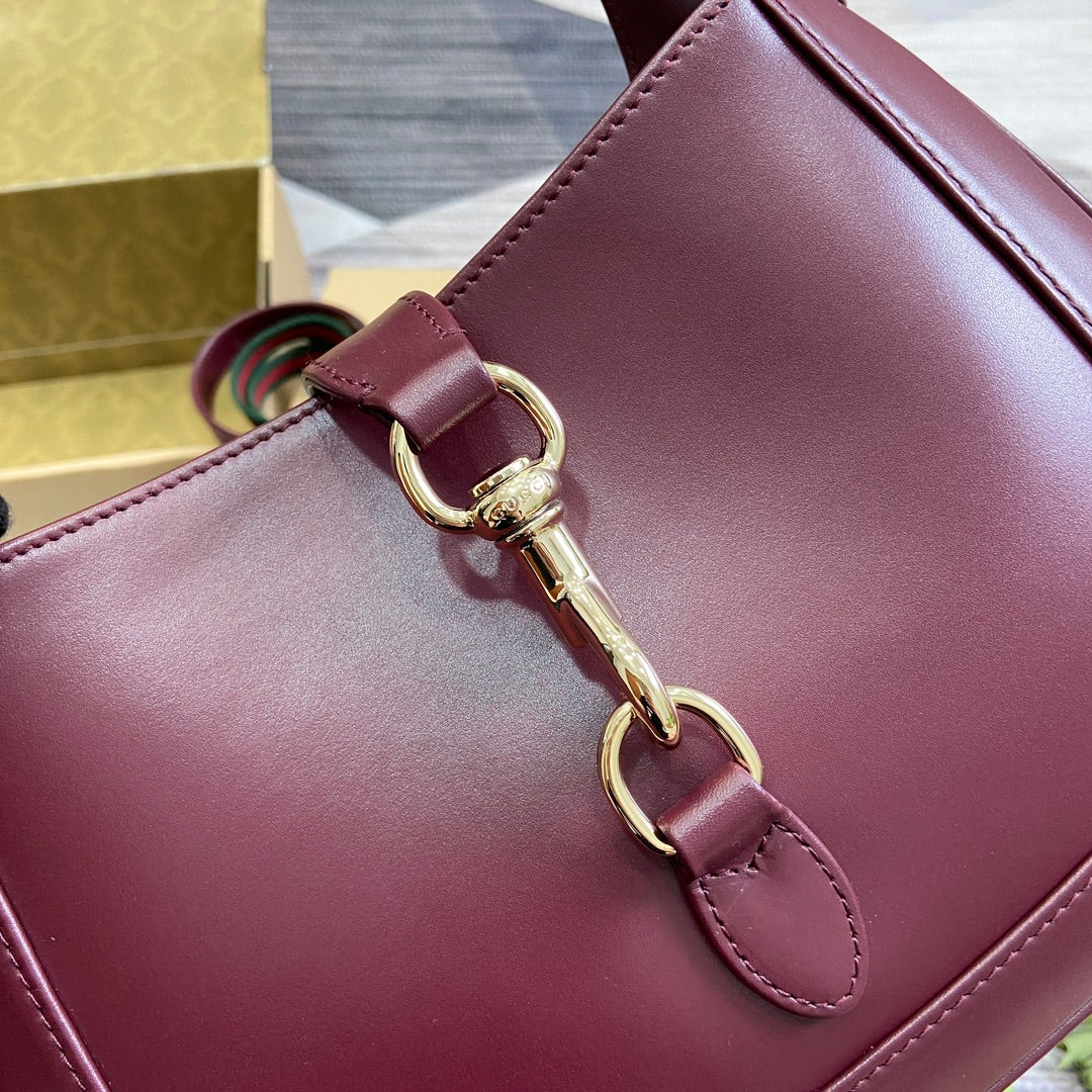 Petit sac bandoulière Jackie 27 en cuir de veau bordeaux et métal doré