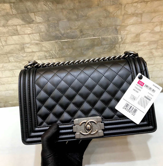 SAC GARÇON MOYEN 25 EN CUIR D'AGNEAU MATELASSÉ NOIR, QUINCAILLERIE EN RUTHÉNIUM VIEILLI