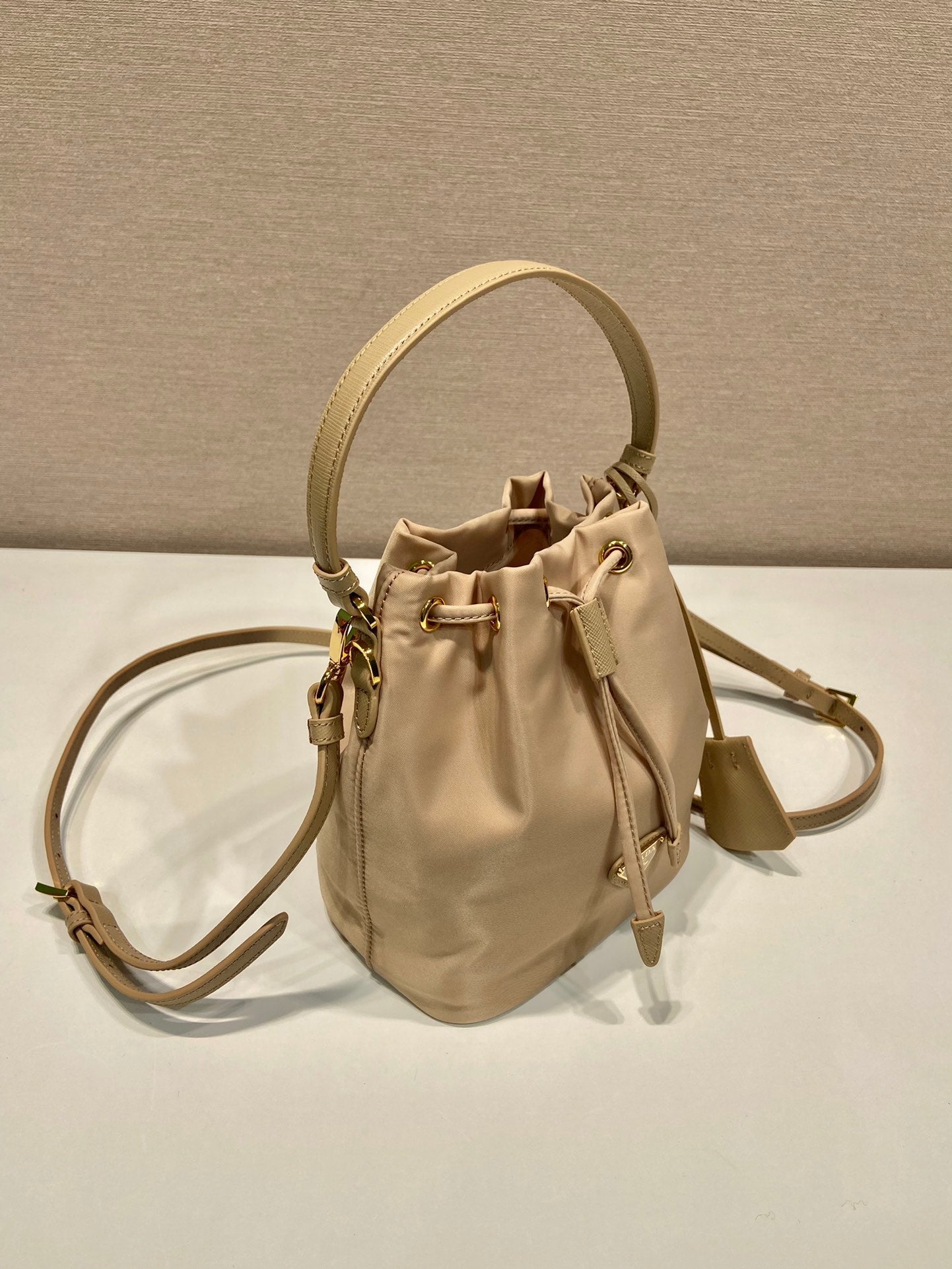 SAC SEAU 19 EN RE-NYLON BEIGE ET POIGNÉE EN CUIR SAFFIANO