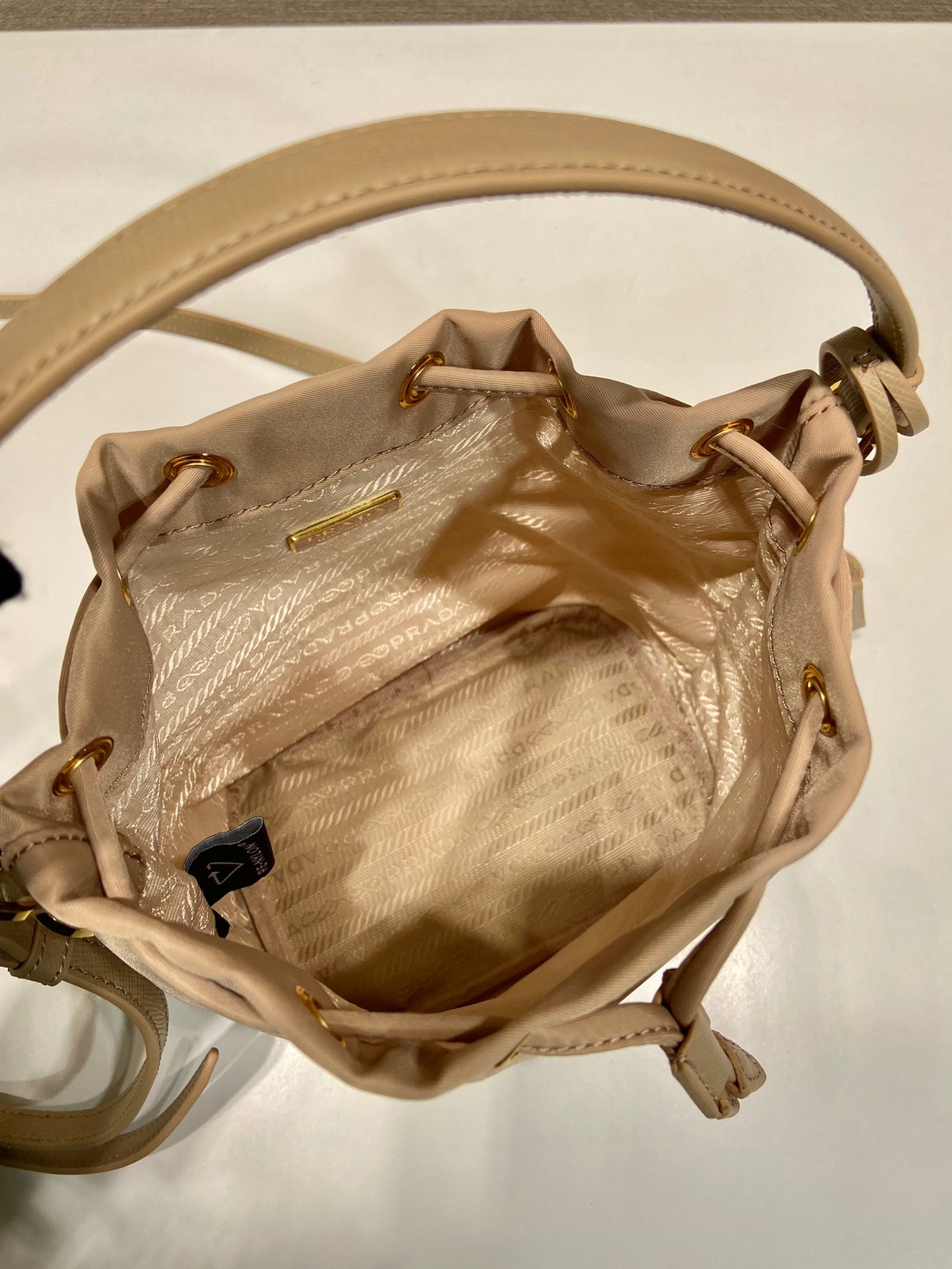 SAC SEAU 19 EN RE-NYLON BEIGE ET POIGNÉE EN CUIR SAFFIANO
