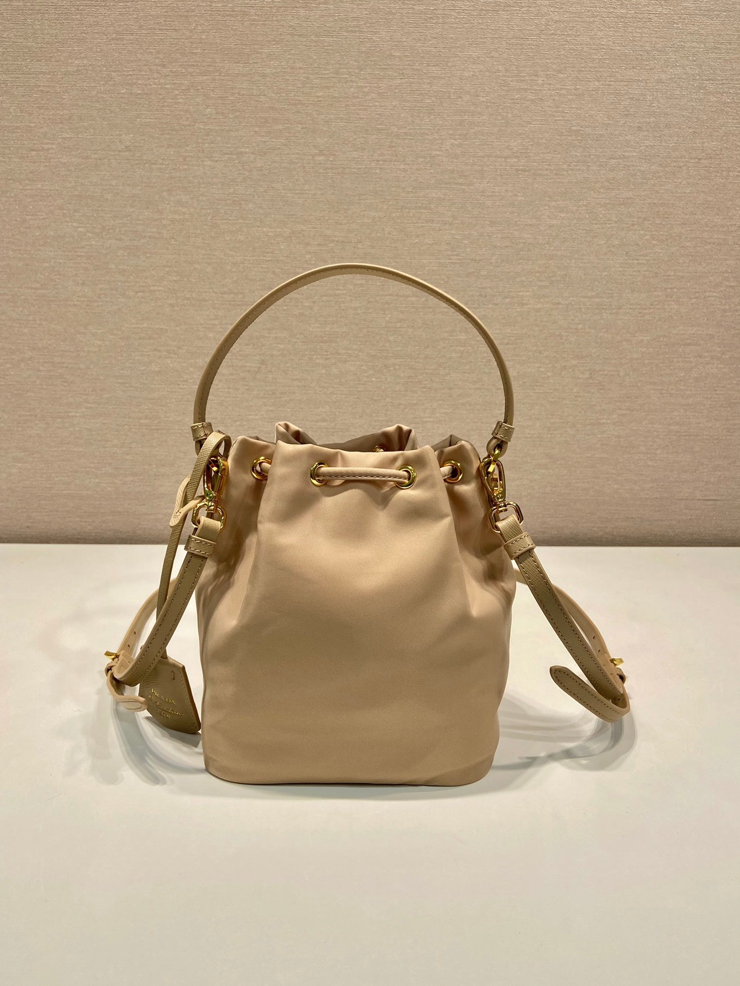 SAC SEAU 19 EN RE-NYLON BEIGE ET POIGNÉE EN CUIR SAFFIANO