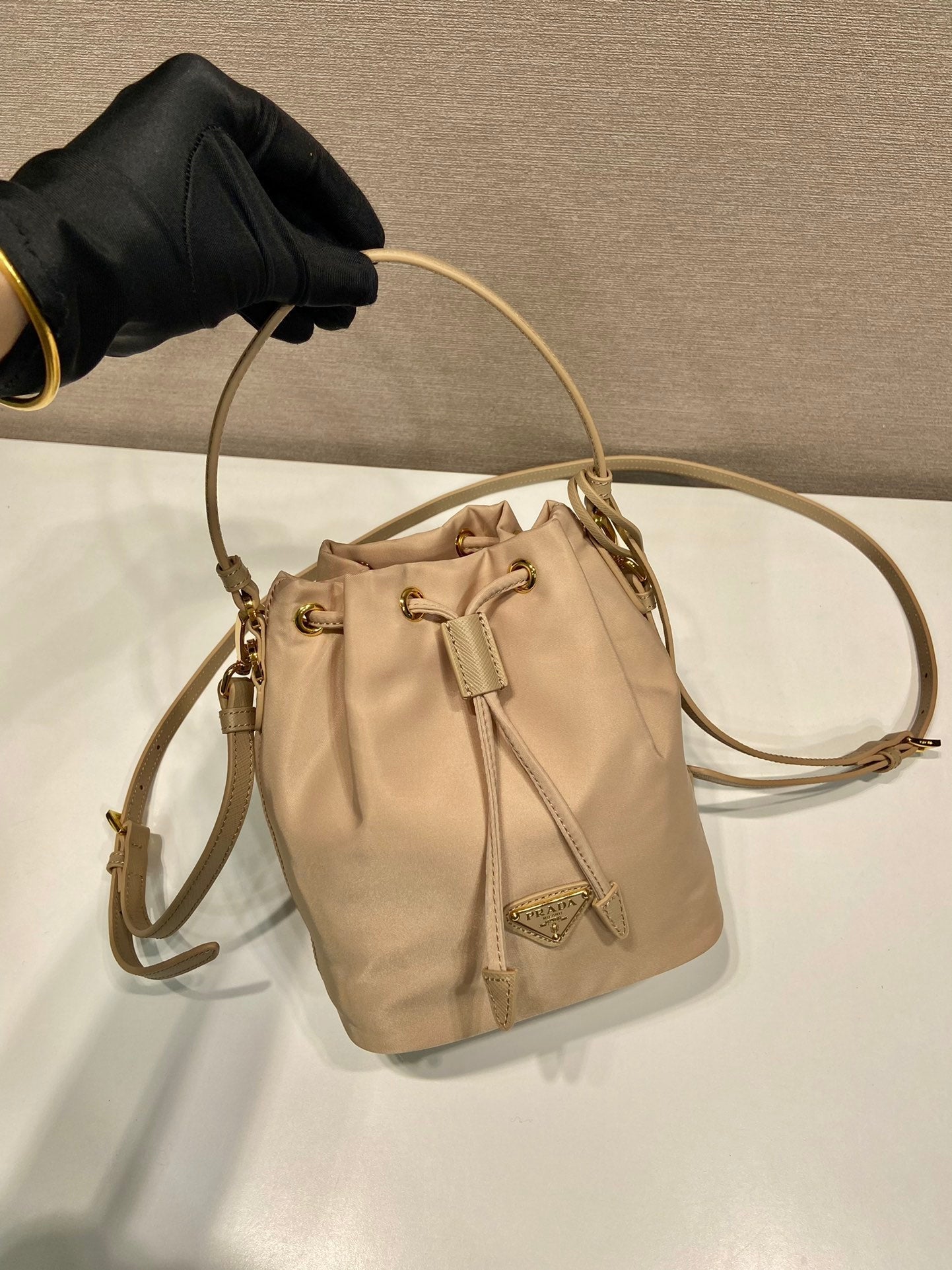 SAC SEAU 19 EN RE-NYLON BEIGE ET POIGNÉE EN CUIR SAFFIANO