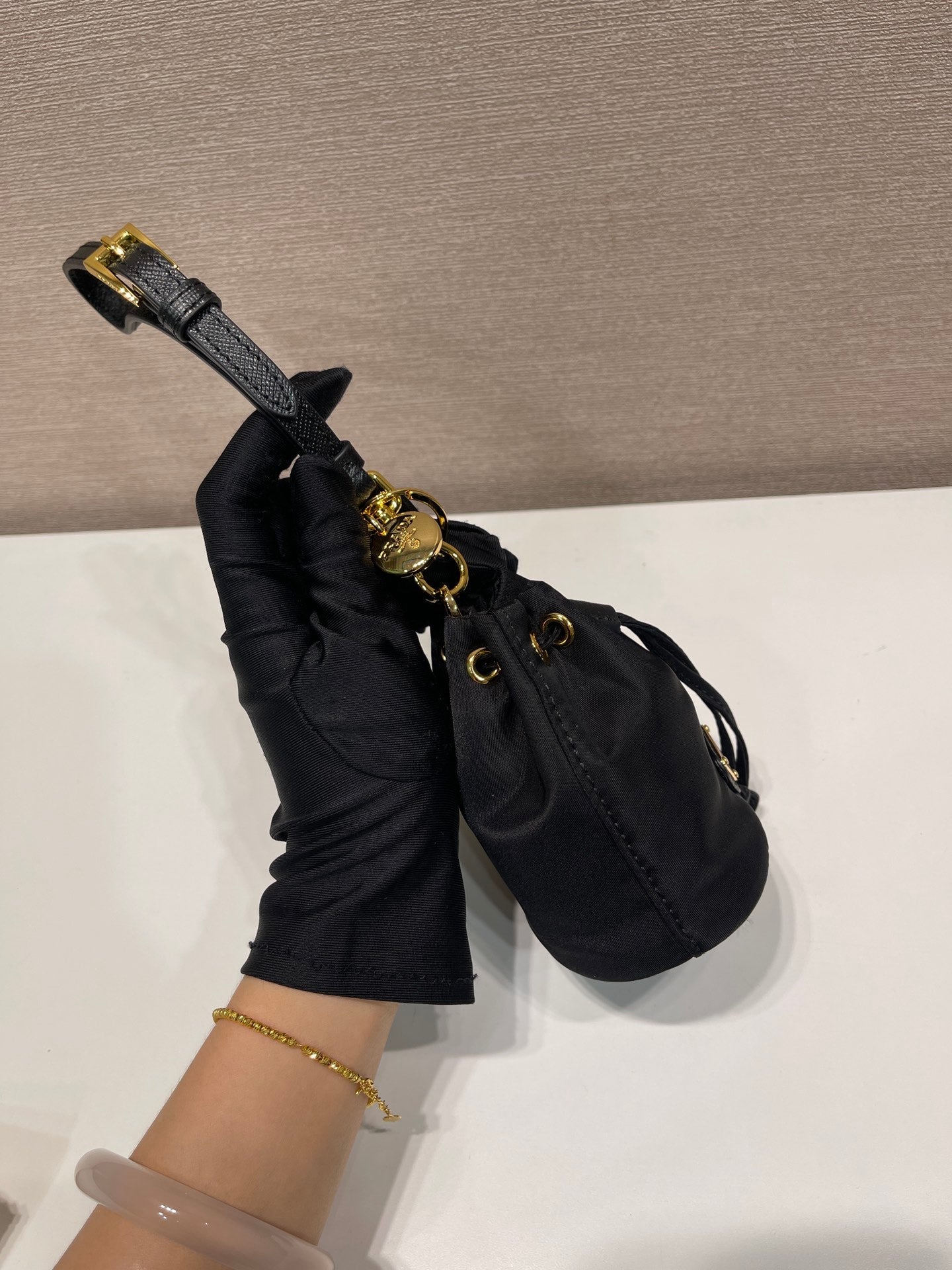 MINI SAC SEAU 10 EN RE-NYLON NOIR ET BANDOULIÈRE EN CUIR SAFFIANO