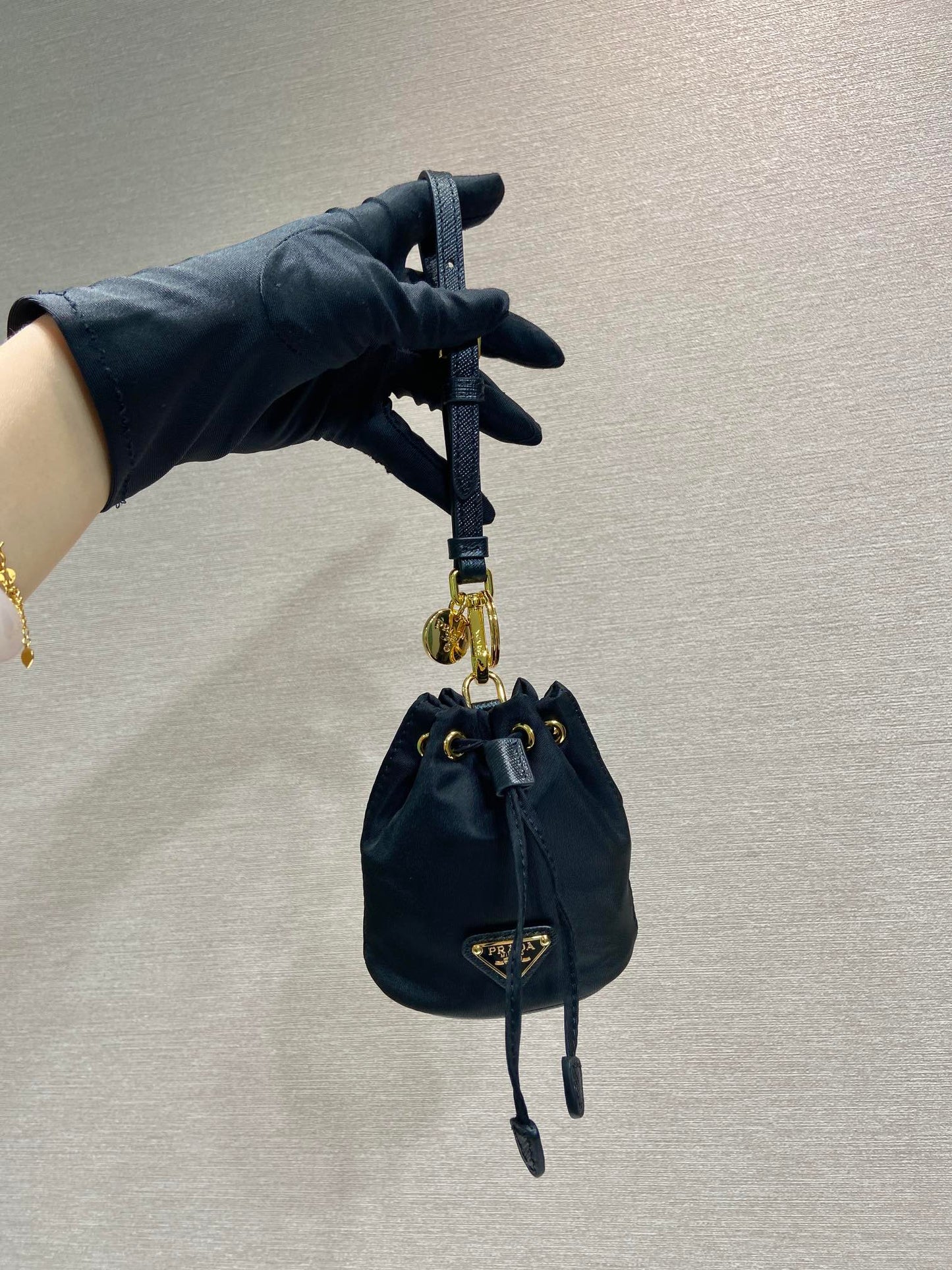MINI SAC SEAU 10 EN RE-NYLON NOIR ET BANDOULIÈRE EN CUIR SAFFIANO