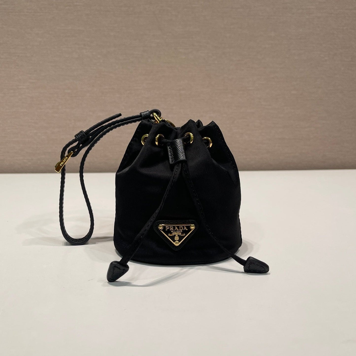 MINI SAC SEAU 10 EN RE-NYLON NOIR ET BANDOULIÈRE EN CUIR SAFFIANO