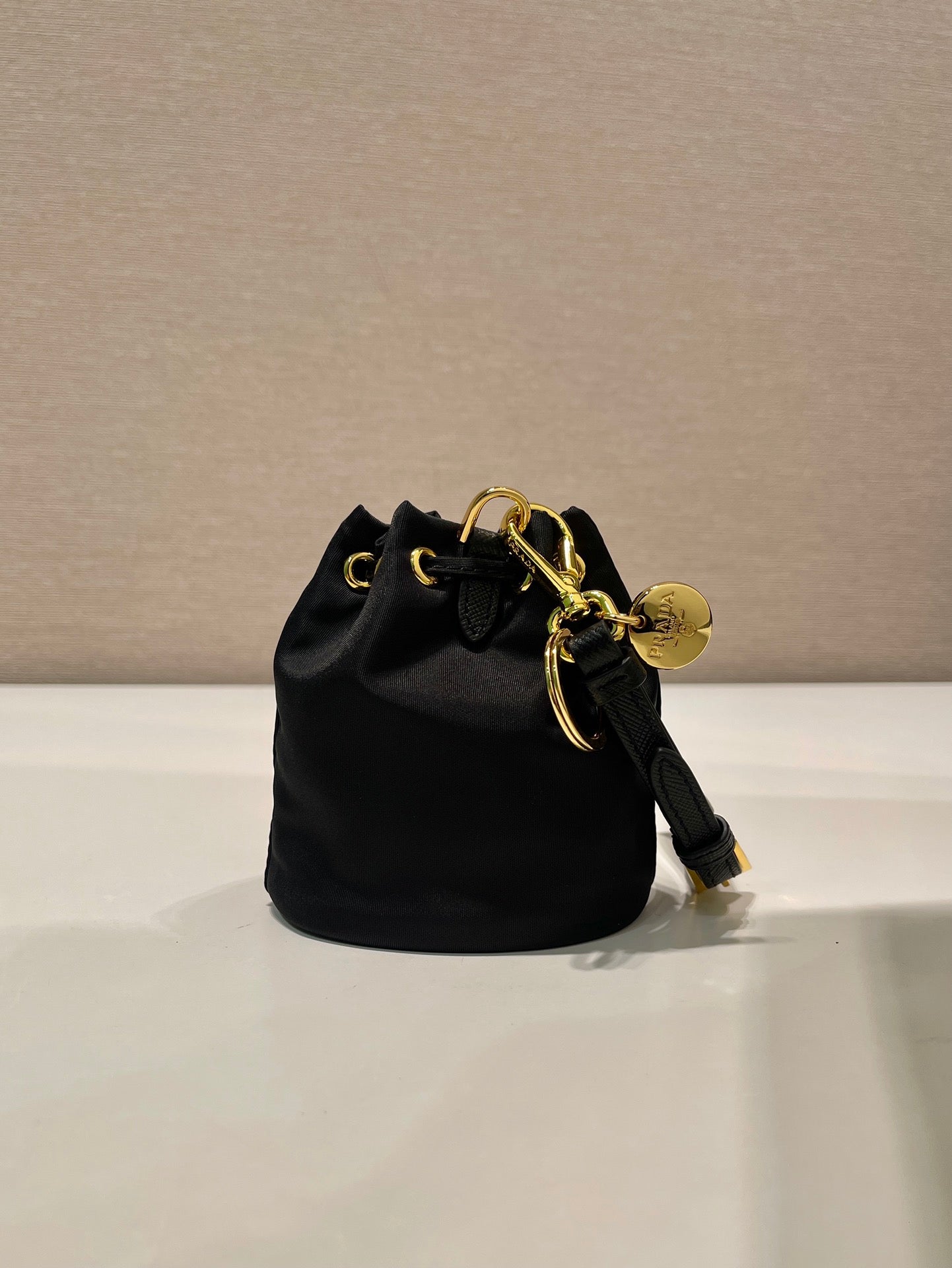 MINI SAC SEAU 10 EN RE-NYLON NOIR ET BANDOULIÈRE EN CUIR SAFFIANO