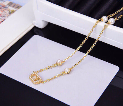 Collier pendentif CD en or, diamants et 4 perles