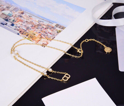 Collier pendentif CD en or, diamants et 4 perles