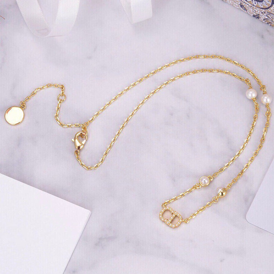 Collier pendentif CD en or, diamants et 4 perles