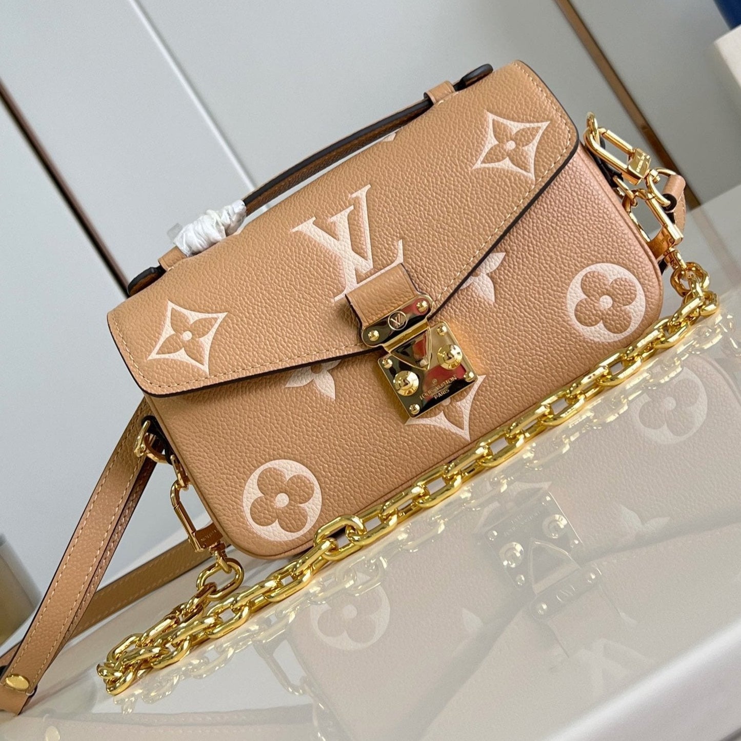 Pochette Metis East West 21,5 en cuir de veau monogrammé marron et blanc