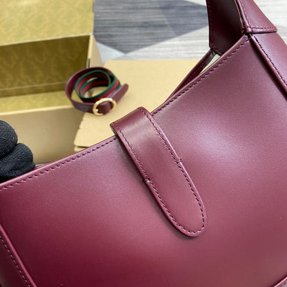 Petit sac bandoulière Jackie 27 en cuir de veau bordeaux et métal doré