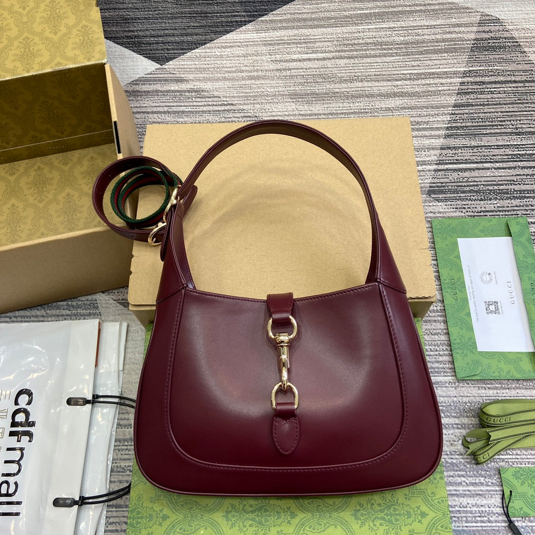 Petit sac bandoulière Jackie 27 en cuir de veau bordeaux et métal doré
