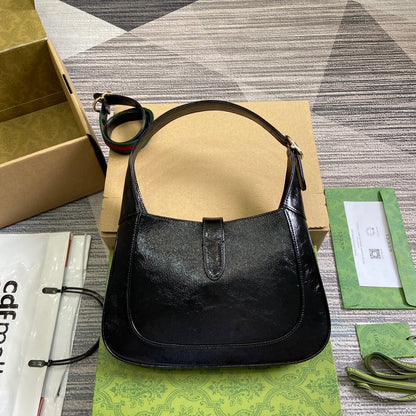 Petit sac bandoulière Jackie 27 en cuir de veau laqué craquelé noir, matériel doré 