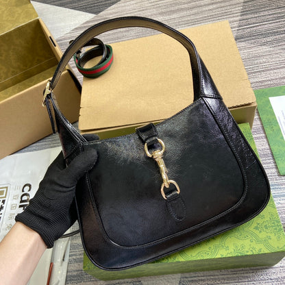 Petit sac bandoulière Jackie 27 en cuir de veau laqué craquelé noir, matériel doré 