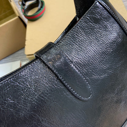 Petit sac bandoulière Jackie 27 en cuir de veau laqué craquelé noir, matériel doré 