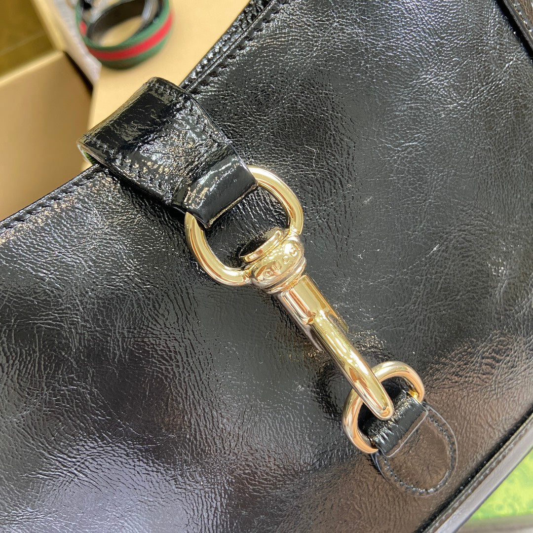 Petit sac bandoulière Jackie 27 en cuir de veau laqué craquelé noir, matériel doré 