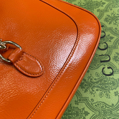 Petit sac bandoulière Jackie 27 en cuir de veau laqué craquelé orange, matériel doré 
