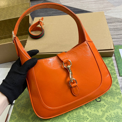Petit sac bandoulière Jackie 27 en cuir de veau laqué craquelé orange, matériel doré 