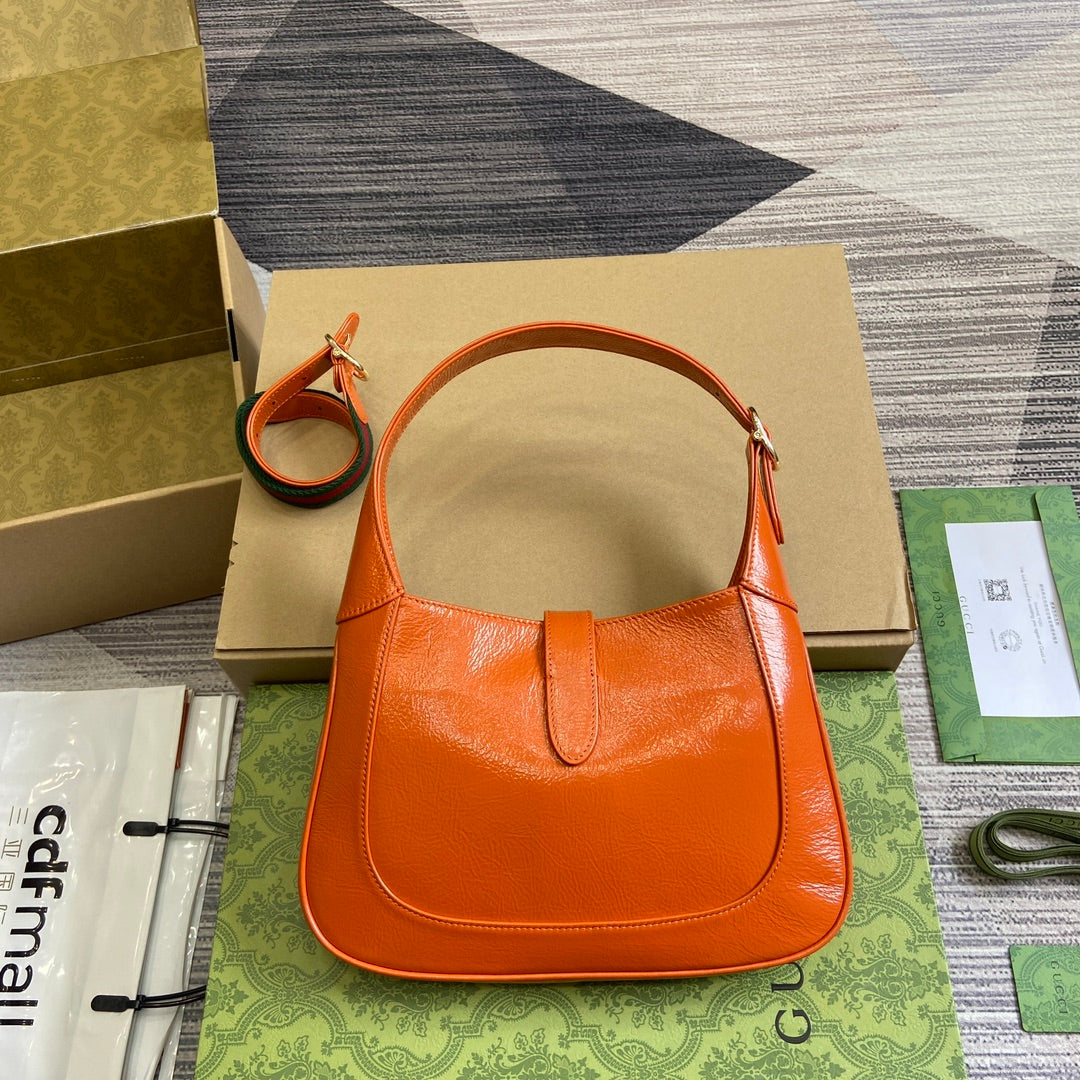 Petit sac bandoulière Jackie 27 en cuir de veau laqué craquelé orange, matériel doré 