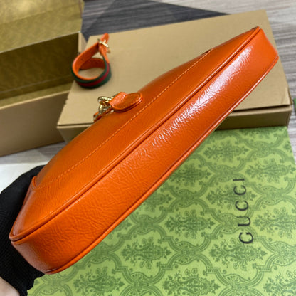 Petit sac bandoulière Jackie 27 en cuir de veau laqué craquelé orange, matériel doré 