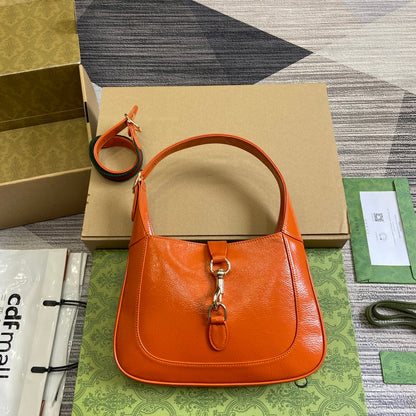 Petit sac bandoulière Jackie 27 en cuir de veau laqué craquelé orange, matériel doré 