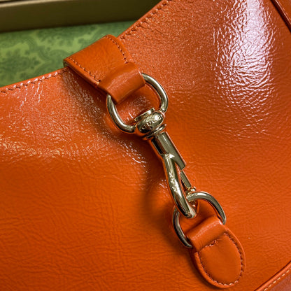 Petit sac bandoulière Jackie 27 en cuir de veau laqué craquelé orange, matériel doré 