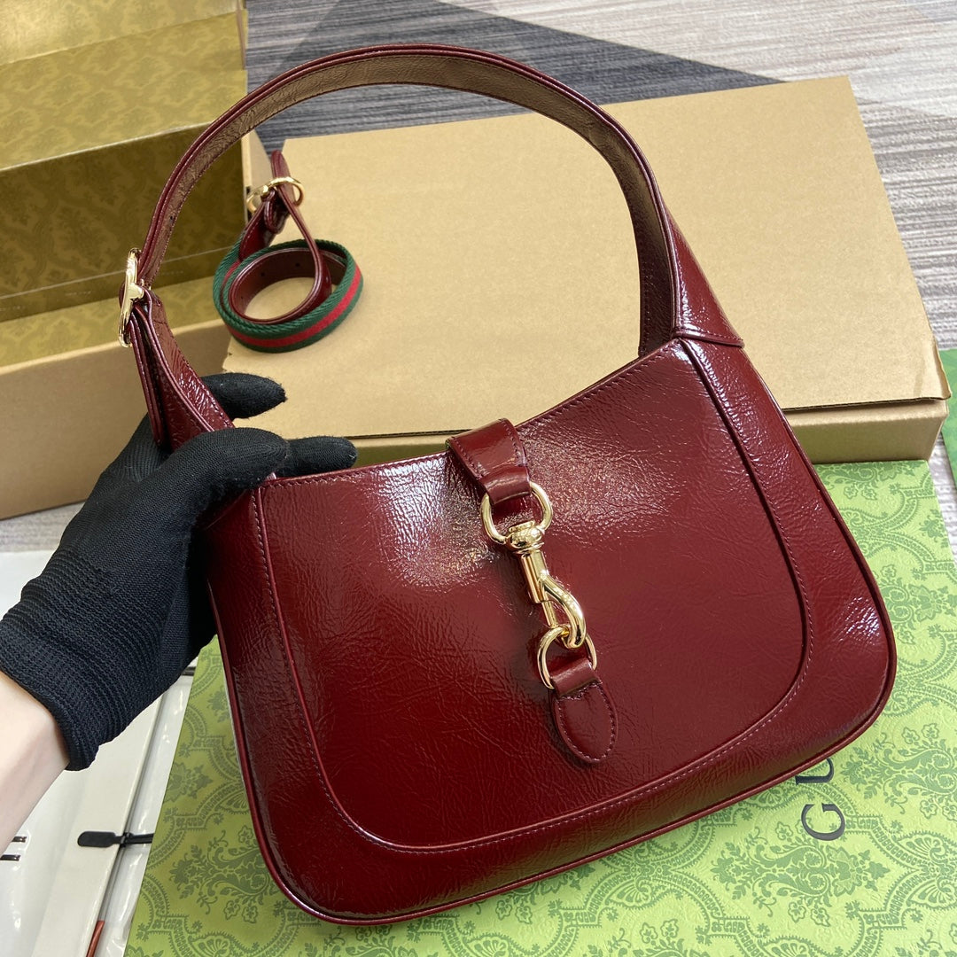 Petit sac bandoulière Jackie 27 en cuir de veau laqué craquelé rouge vin, accessoires dorés