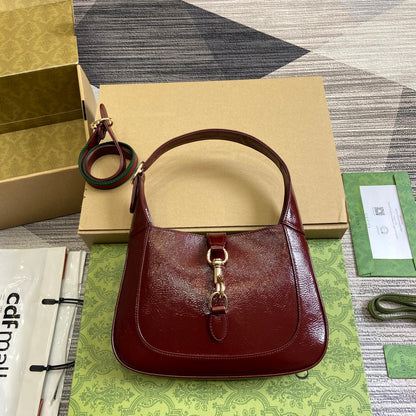 Petit sac bandoulière Jackie 27 en cuir de veau laqué craquelé rouge vin, accessoires dorés