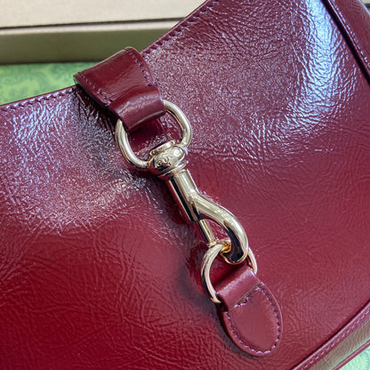 Petit sac bandoulière Jackie 27 en cuir de veau laqué craquelé rouge vin, accessoires dorés