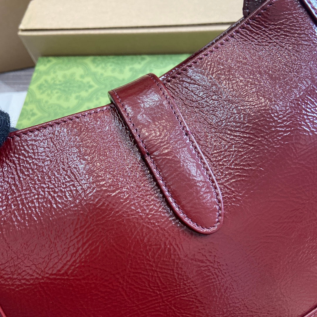 Petit sac bandoulière Jackie 27 en cuir de veau laqué craquelé rouge vin, accessoires dorés
