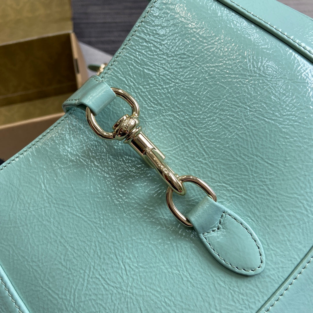 Petit sac bandoulière Jackie 27 en cuir de veau laqué craquelé vert menthe, accessoires dorés 