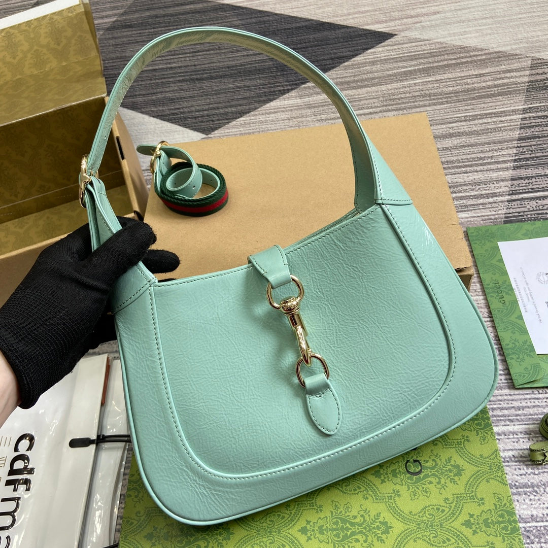 Petit sac bandoulière Jackie 27 en cuir de veau laqué craquelé vert menthe, accessoires dorés 