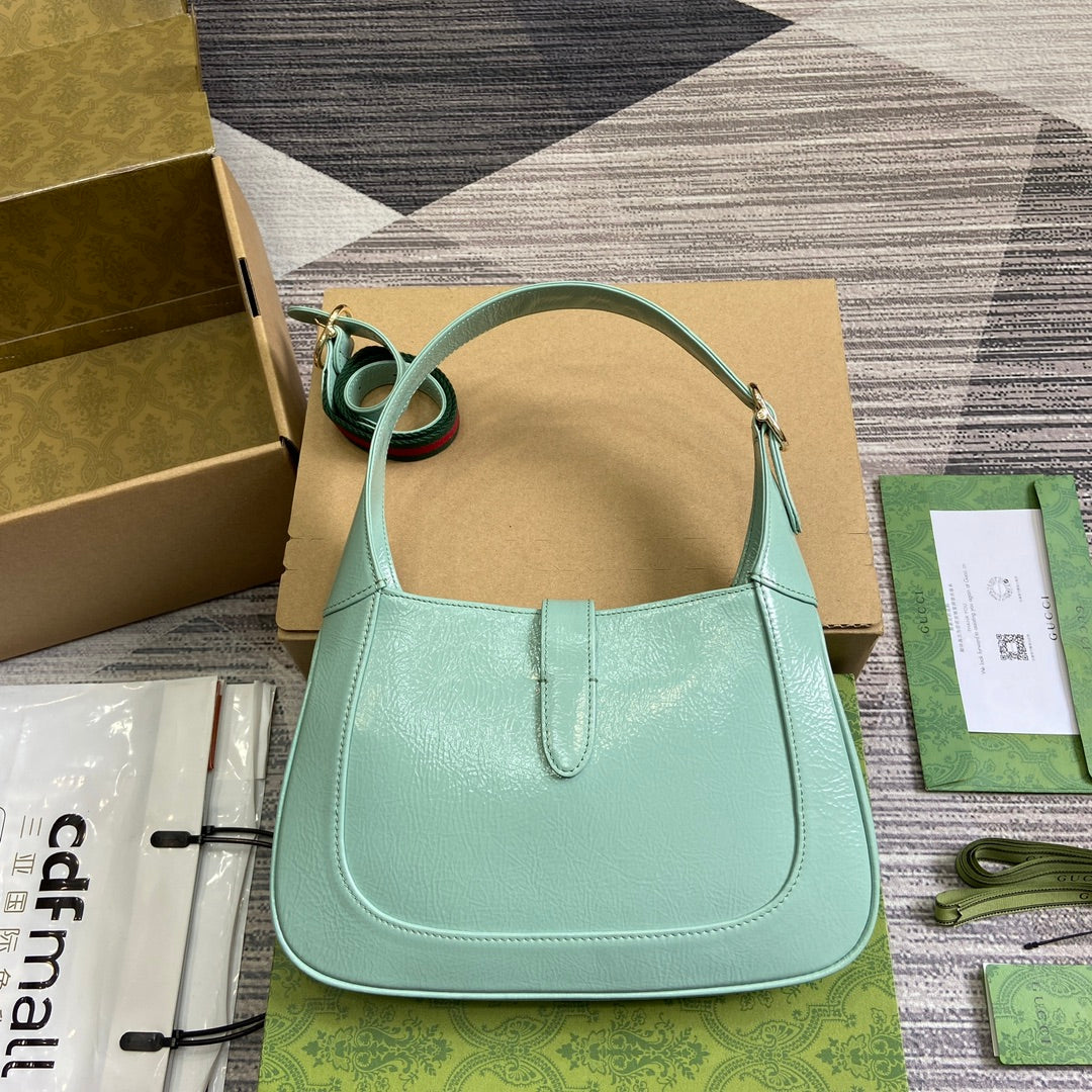 Petit sac bandoulière Jackie 27 en cuir de veau laqué craquelé vert menthe, accessoires dorés 
