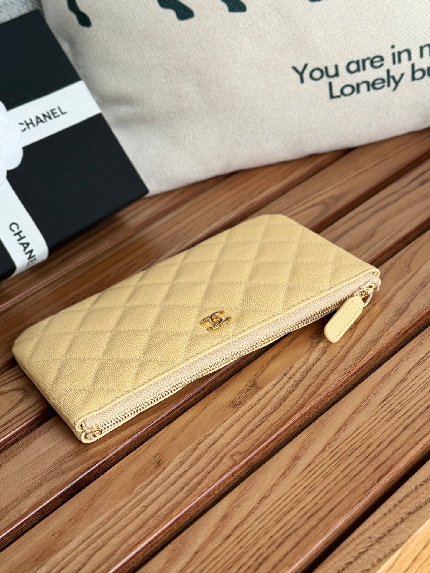 Portefeuille zippé CC 20 cm en caviar matelassé jaune clair, finitions dorées