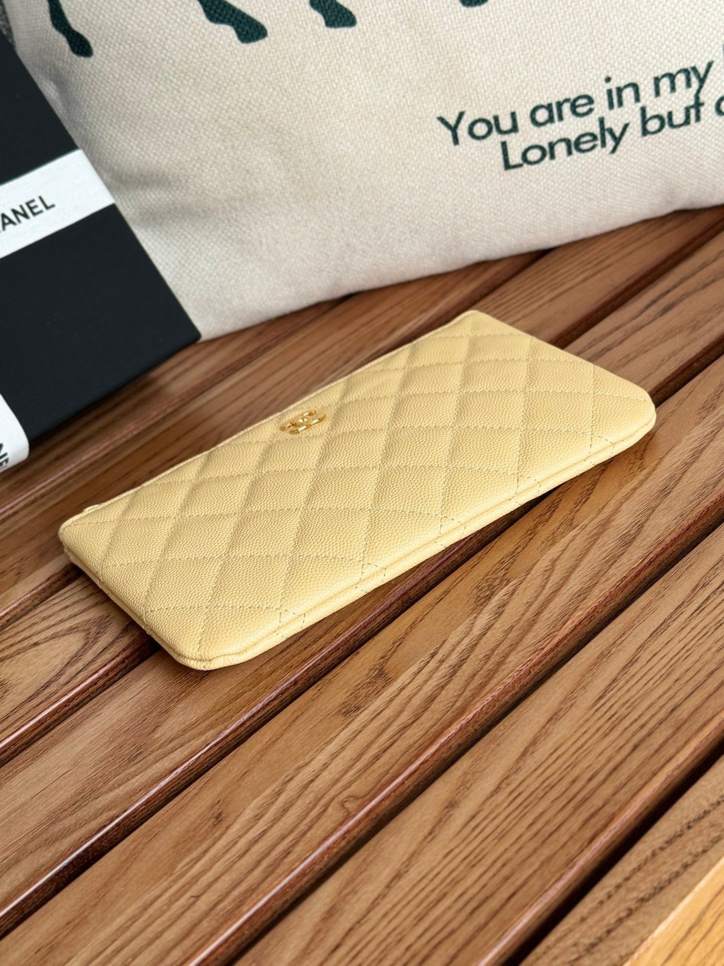 Portefeuille zippé CC 20 cm en caviar matelassé jaune clair, finitions dorées