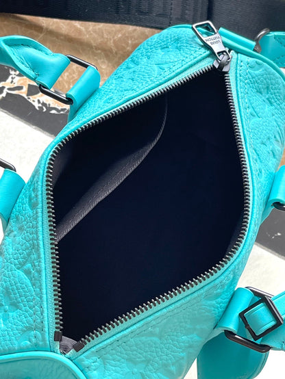 Sac bandoulière Keepall 25 en cuir de veau embossé monogramme bleu turquoise